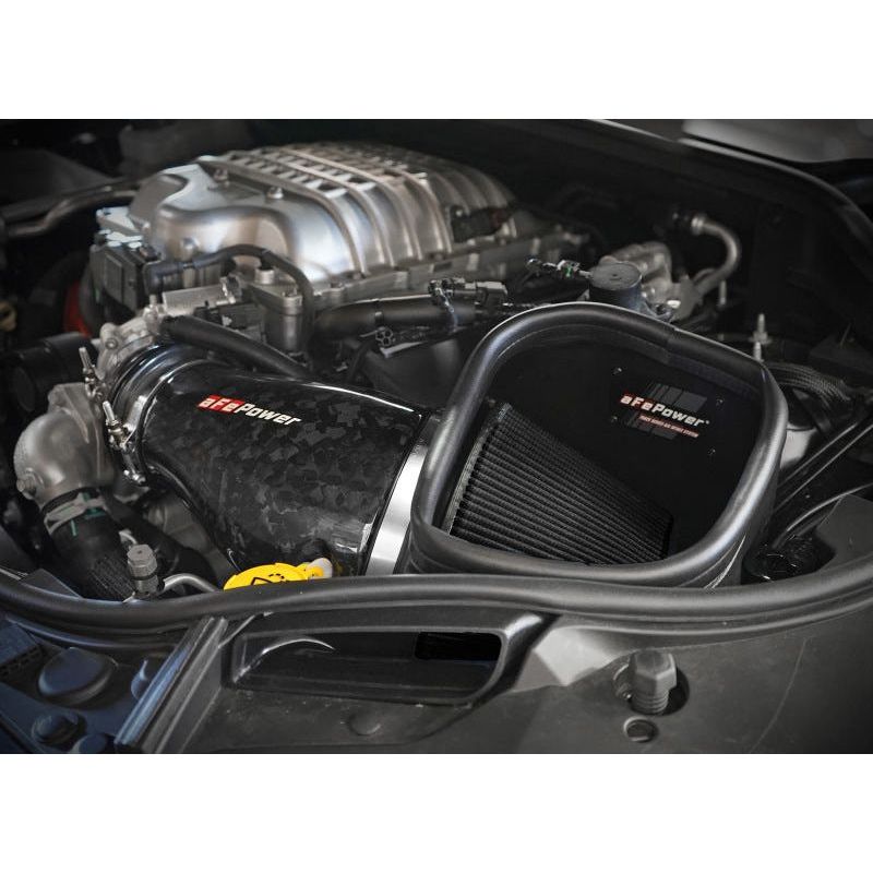 Cold air intake system with carbon fiber tube and black filter installed in the engine bay of a vehicle.
